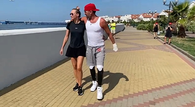 Публика смотрит на протезы, пока Костомаров с женой гуляют по набережной