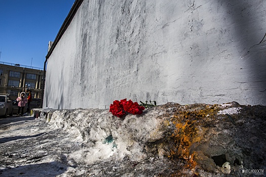 К стене, на которой закрасили популярное граффити, положили траурные цветы