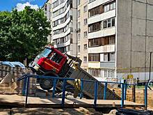 Самосвал с песком съехал в котлован во дворе дома в Москве