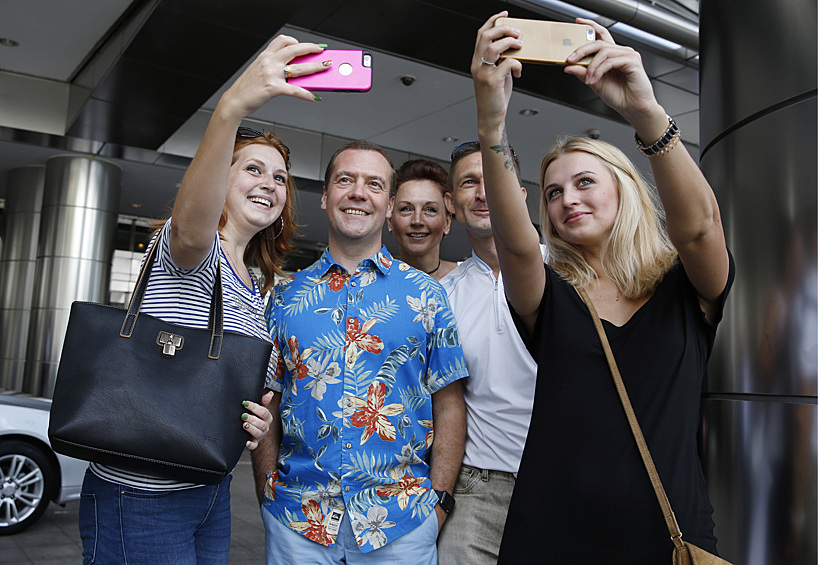 Премьер-министр РФ Дмитрий Медведев фотографируется с туристами у башен Петронас, Куала-Лумпур