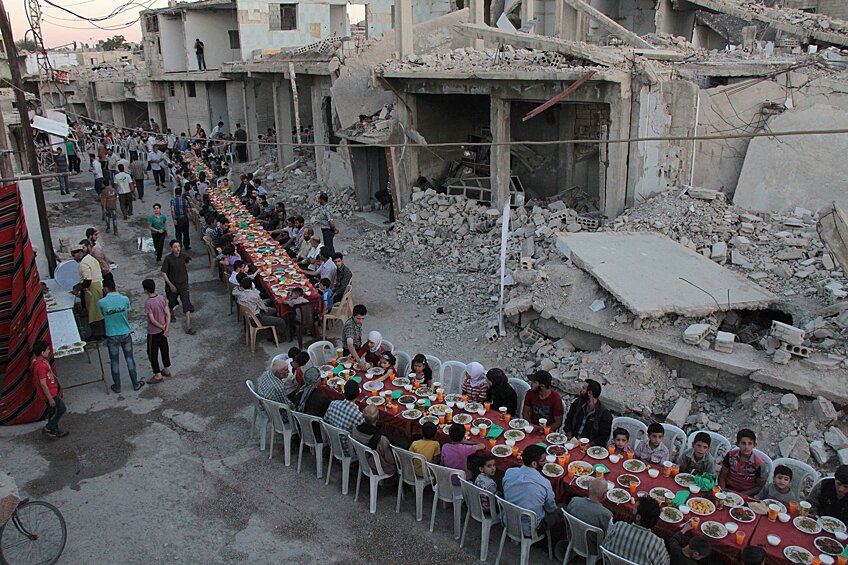 Прием пищи во время Рамадана на одной из разрушенных улиц Думы, Сирия