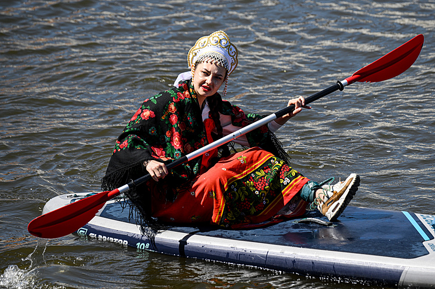 Участница костюмированной сап-регаты, проходящей в рамках фестиваля "Москва - на волне. Рыбная неделя" на Водоотводном канале в Москве