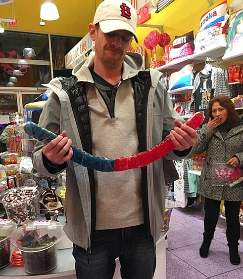 Вот эта длинная конфетка. Даже женщина ей удивлена.