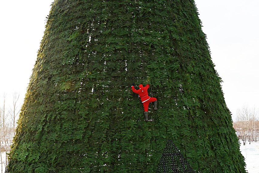 Монтажник-высотник Дмитрий Иванов в костюме Санта-Клауса во время установки главной новогодней елки высотой 55 метров на острове Татышев посреди реки Енисей в Красноярске.