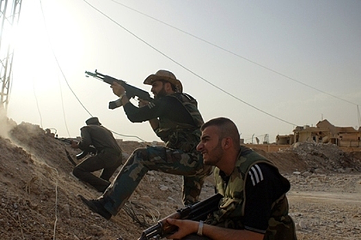 Сирийские военные и ополченцы ведут бой с боевиками ИГИЛ на окраине города Эль-Хасака