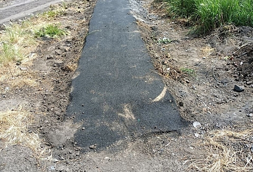 Омичи высмеяли кусок тротуара, уложенный посреди грязи