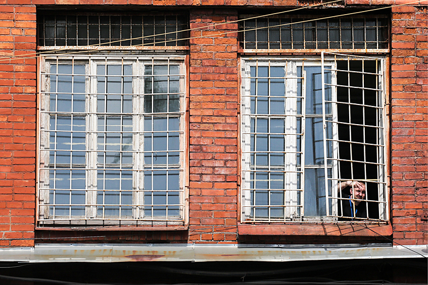 Заключенный выглядывает из окна одного из корпусов ФКУ СИЗО-1 "Кресты" 