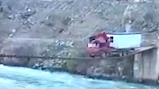 Без права на ошибку: огромный грузовик c домом проехал по узкому мосту над рекой