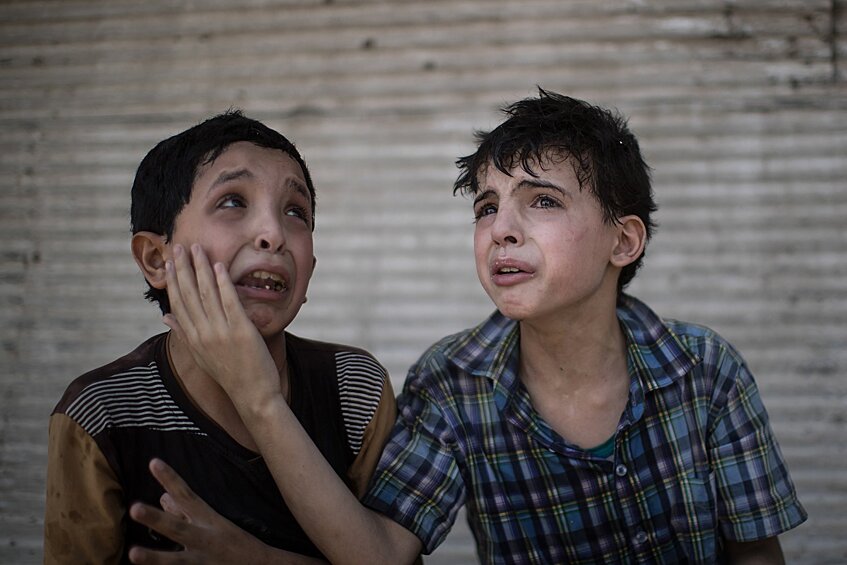 12-летний Заид Али и 11-летний Ходайфа Али утешают друг друга рядом с их разрушенным домом, Мосул, Ирак
