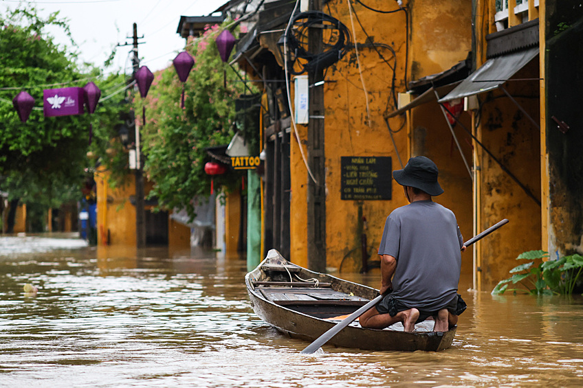 Местный житель передвигается на лодке во время наводнения в Хойане