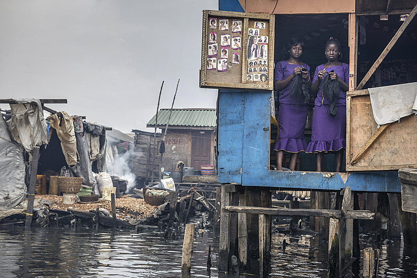 Женщины ткут в трущобах Лагоса, Нигерия. Из-за загрязнения воды население находится под угрозой выселения.