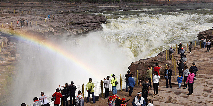 Туристы любуются очистившимся от ила и песка водопадом Хукоу