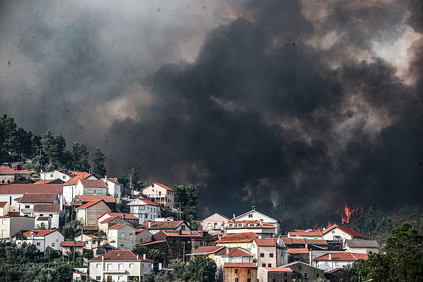 Черный дым поднимается в воздух позади городка Алдея-де-Меас, Португалия, 17 августа 2025 года