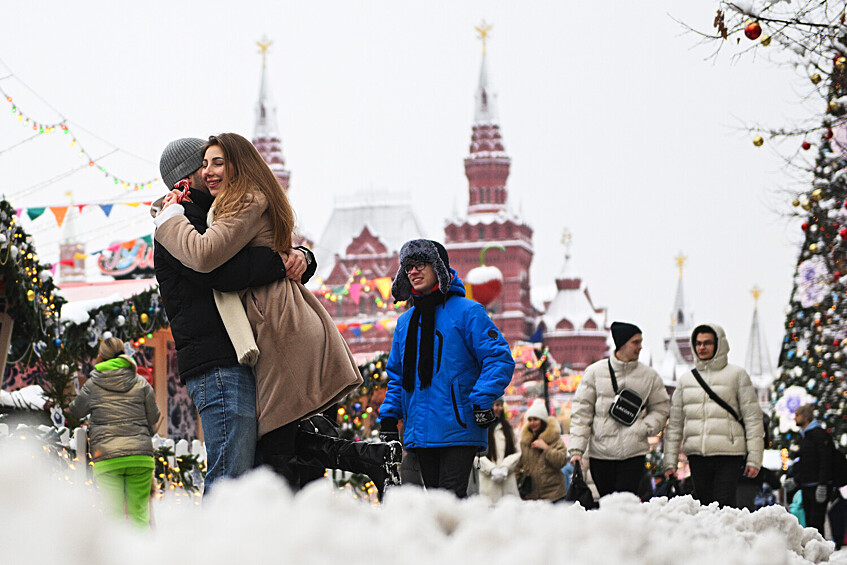 Люди и новогодние украшения на Манежной площади в Москве