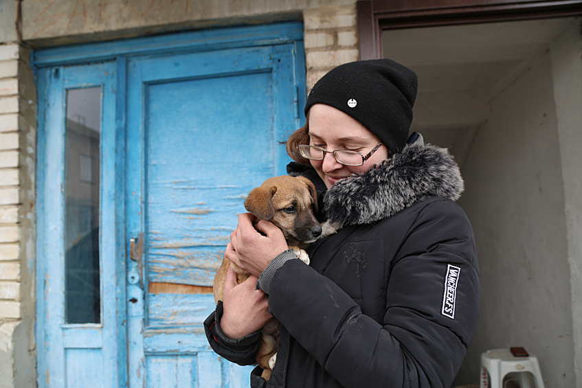 Женщина с щенком на руках в селе Николаевка в Донецкой народной республике