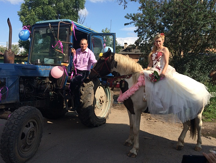 Русские деревенские невесты долго не размышляют над транспортом. Всё есть в конюшне. С ветерком прискакала на коне, чтоб не заставлять ждать жениха, который приедет на тракторе.