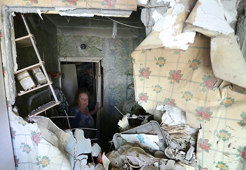 Женщина в квартире, пострадавшей в результате обстрелов поселка Октябрьский Куйбышевского района.