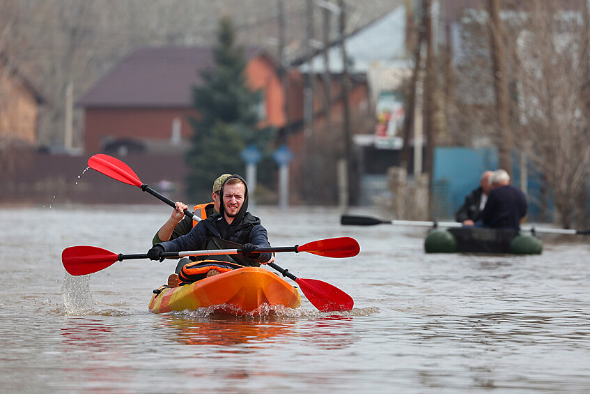 Люди в лодке на затопленной улице в микрорайоне Кузнечный в Оренбурге, 10 апреля 2024 года