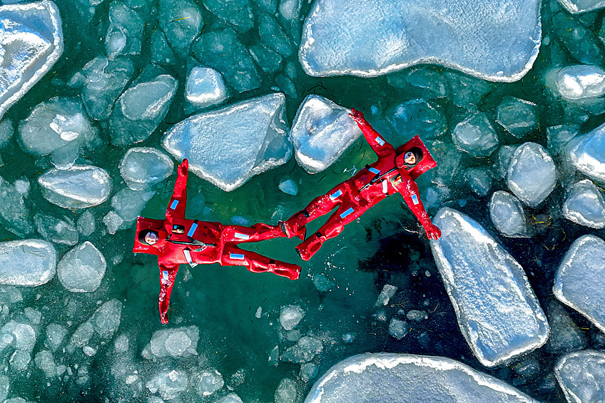 Люди во время купания в гидрокостюмах в акватории бухты Ахлестышева, январь 2025 года