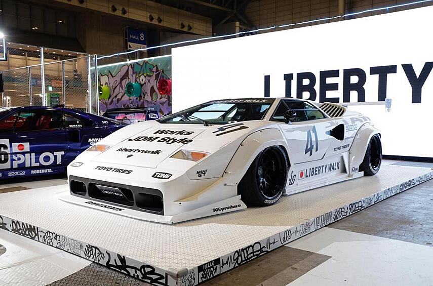 Компания Liberty Walk не стесняется работать с суперкарами элитных марок — хоть Ferrari, хоть Lamborghini. Вот и на этот раз стенд японской фирмы украшал Lamborghini Countach в обвесе вызывающего вида, к тому же осаженный пневмоподвеске.