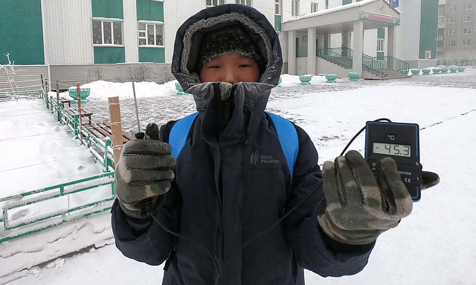  Мальчик держит в руках цифровой термометр с датчиком на улице в Якутске, 2019 год