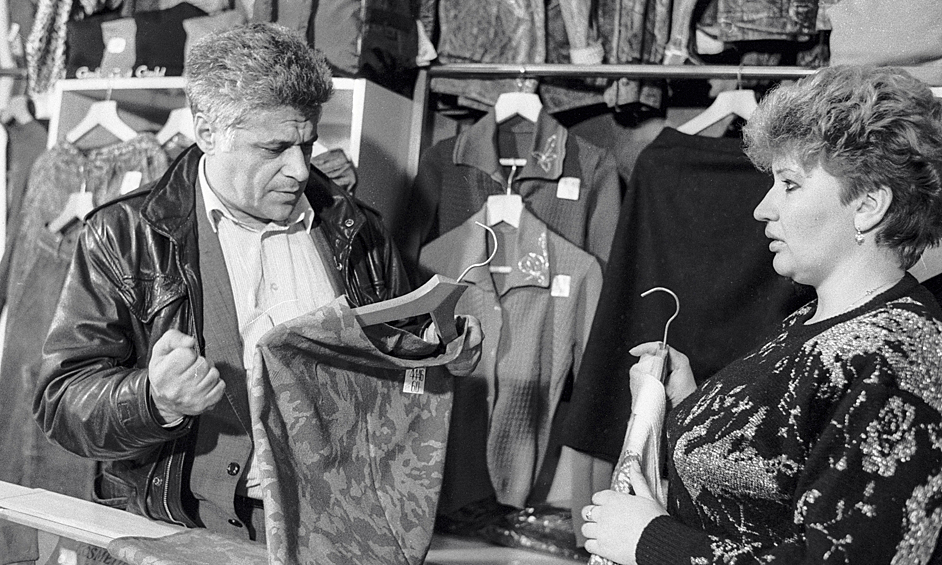 Председатель кооператива «Торгсервис» рассматривает  одежду в одном из своих магазинов, 1989 год