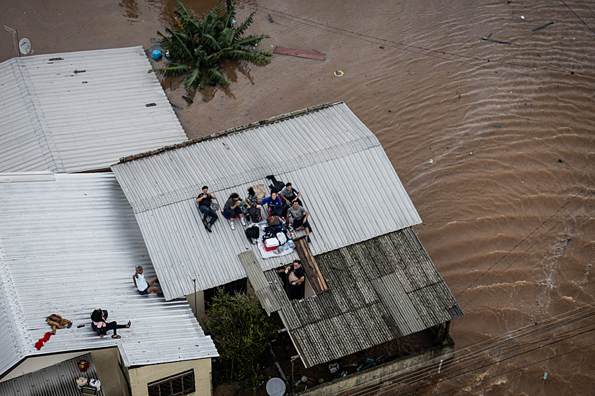 Люди на крыше дома ждут вертолет бразильской армии