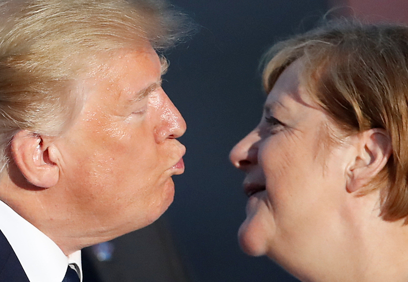 Президент США Дональд Трамп и канцлер Германии Ангела Меркель поцеловались во время семейной фотосессии с приглашенными гостями на саммите G7 в Биаррице, 2019 год