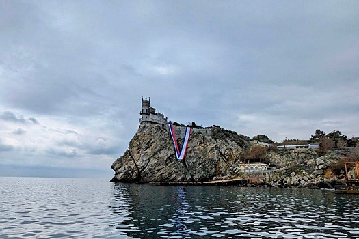 На скале у замка Ласточкино гнездо развернули огромные флаги России и Крыма