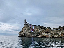 На скале у замка Ласточкино гнездо развернули огромные флаги России и Крыма