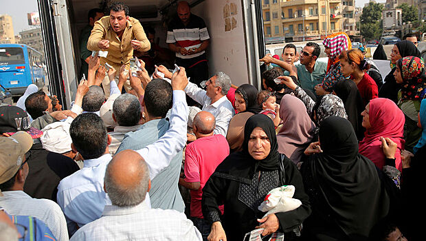 Продажа субсидированного сахара с правительственного грузовика местным жителям в Каире