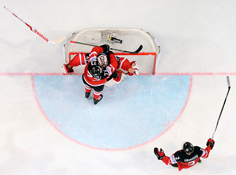 Игроки сборной Канады Дэн Хэмьюс, Тайлер Тоффоли и вратарь сборной Канады Майк Смит (справа налево) радуются победе.