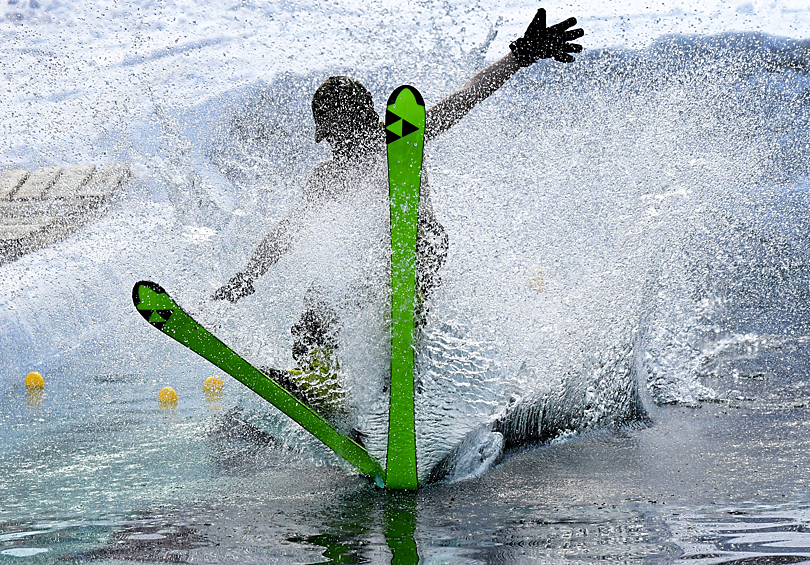 Участник пытается преодолеть на горных лыжах 25-метровый бассейн с водой в 14-х ежегодных шуточных соревнованиях "Горнолужник", которые проходят в связи с закрытием зимнего сезона, в фанпарке "Бобровый лог" в Красноярске