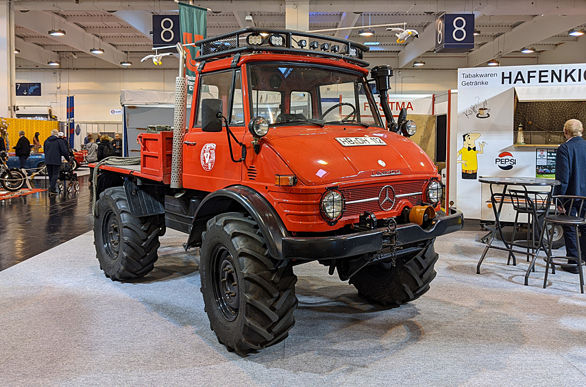 Полноприводный Mercedes-Benz Unimog — одна из легенд Германии: полу-грузовик, полу-трактор. В стране бессчётное количество клубов владельцев, и почти на каждой «Техно-Классике» вы встретите такие машины. А в этом году «Универсальному моторному агрегату» — именно так расшифровывается название — исполняется 75 лет. Перед нами нарядный Unimog 406: такие грузовики выпускались более 25 лет, с 1963 по 1989 год. Судя по наклейкам на дверях и канатам на грузовой платформе, раньше он помогал швартовать корабли в порту Бремена. Для убедительности владельцы грузовика даже притащили на выставку прицеп-ларёк для моряков, когда-то стоявший в порту.