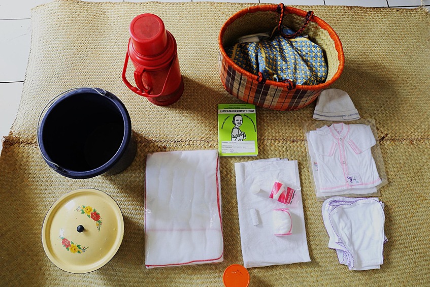 В сумке Клодин: новая детская одежда, вата, спирт для чистки подгузников, термос, ведро и гигиенические прокладки.