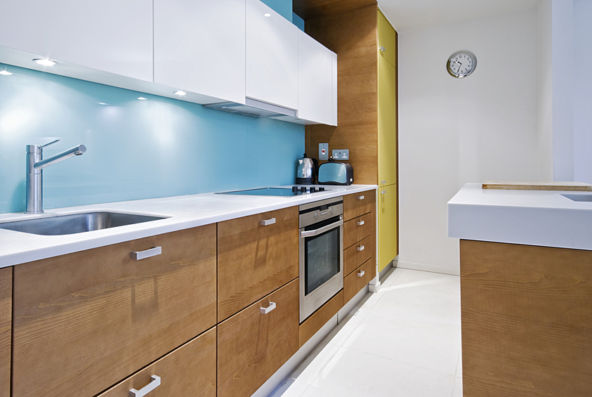Если верхние и нижние шкафы кухни не отличаются по цвету, сделайте их разными по фактуре. Нижний ярус с деревянными фасадами дополните, например,  верхним глянцевым. 