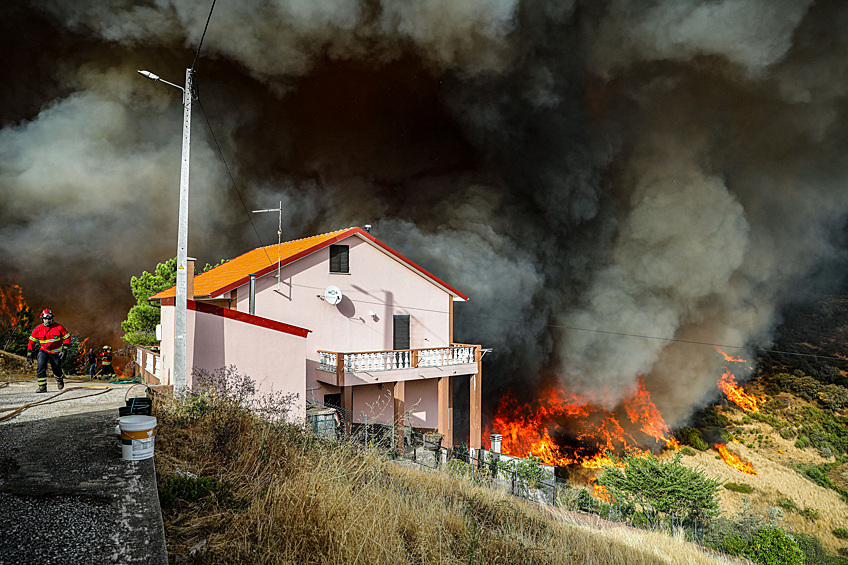 Лесной пожар приближается к дому в Алдея-де-Меас,, Португалия, 17 августа 2025 года