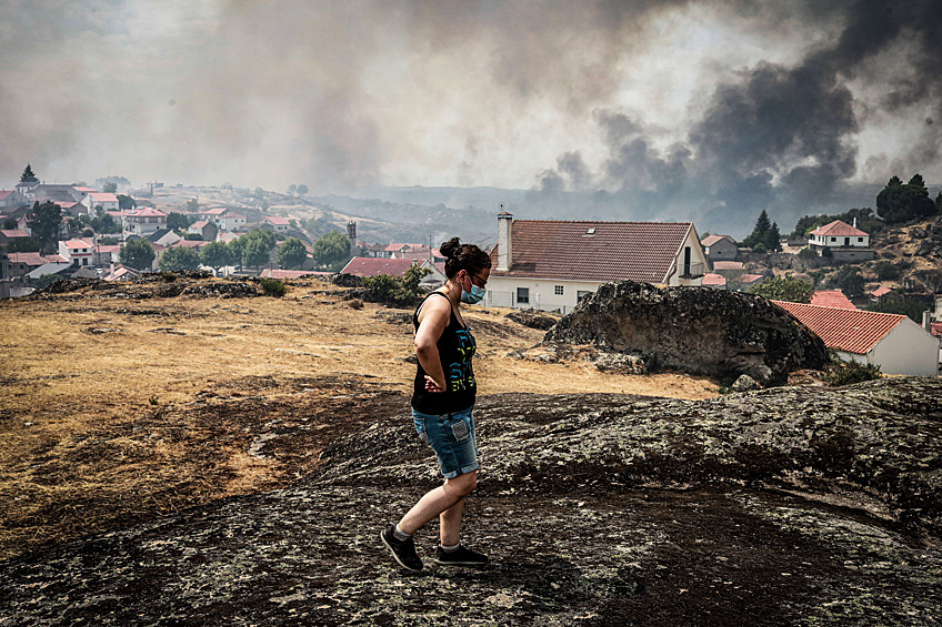 Местная жительца наблюдает за лесным пожаром в Вила-ду-Туру, Португалия, 16 августа 2025 года