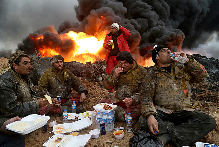 Пожарные во время отдыха между тушением пожаров на нефтяных скважинах. Они были подожжены боевиками запрещенной в России террористической группировки «Исламское государство» в момент отступления