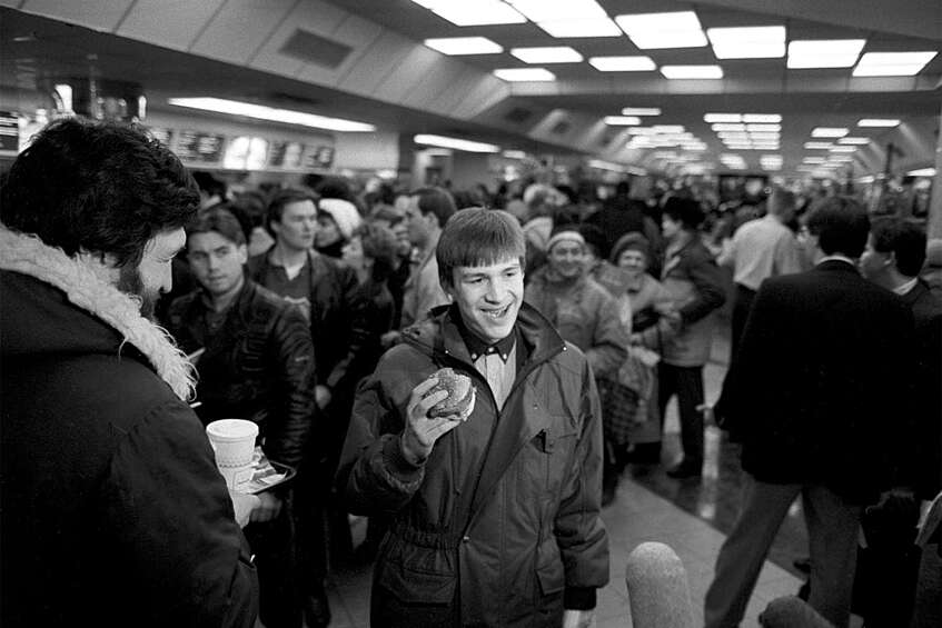 Первые посетители ресторана «Макдоналдс» в Москве. В руке у посетителя Биг-Мак, 31 января 1990 года