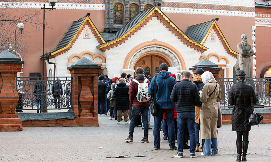 Люди стоят в очереди в Третьяковскую галерею в Москве.