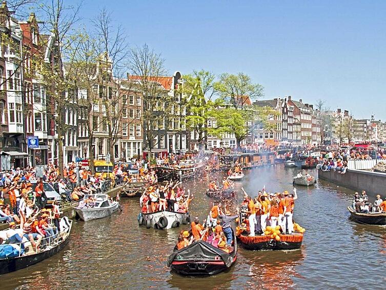 Поучаствуйте в гулянье на Дне Королевы в Амстердаме, когда люди одеваются в оранжевое и всю ночь веселятся.