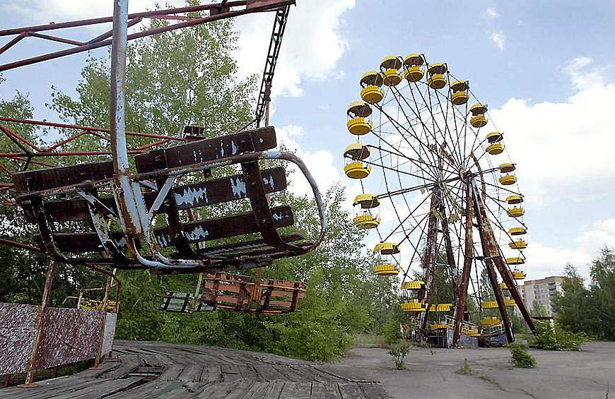 Колесо обозрения и карусель в пустынном парке развлечений города-призрака Припяти по соседству с Чернобыльской АЭС 26 мая 2003 года. Население Припяти, которое в 1986 году составляло 45000 человек, было полностью эвакуировано в течение первых трех дней после взрыва 4‑го реактора №4.