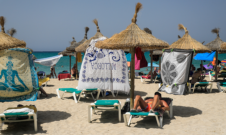 Люди защищаются от солнца с помощью полотенец, Майорка, Испания