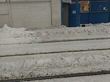 Сошедший с остановочного павильона снег на улице Автономной в Ижевске мешает высадке из трамвая