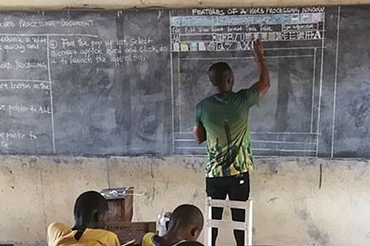 Учитель информатики из Ганы рисует компьютер мелом на доске