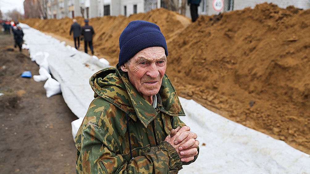Местный житель во время установки водоналивных дамб на улице Галкинской, 14 апреля 2024 года