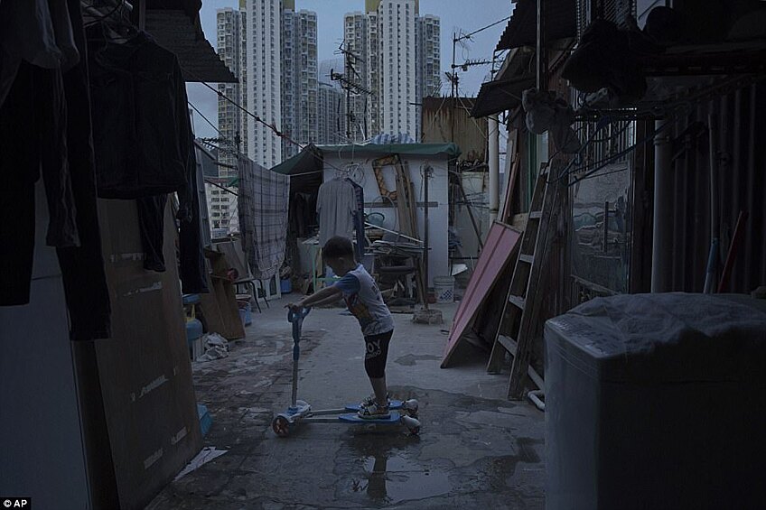 5‑летний мальчик играет около крошечного дома, сделанного из бетона и гофрированного металла, где он живет вместе с родителями.