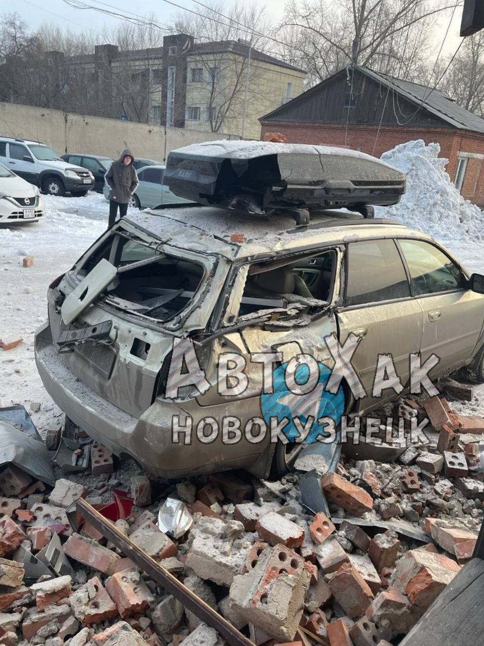 Момент крушения фасада дома на автомобиль в Новокузнецке попал на видео
